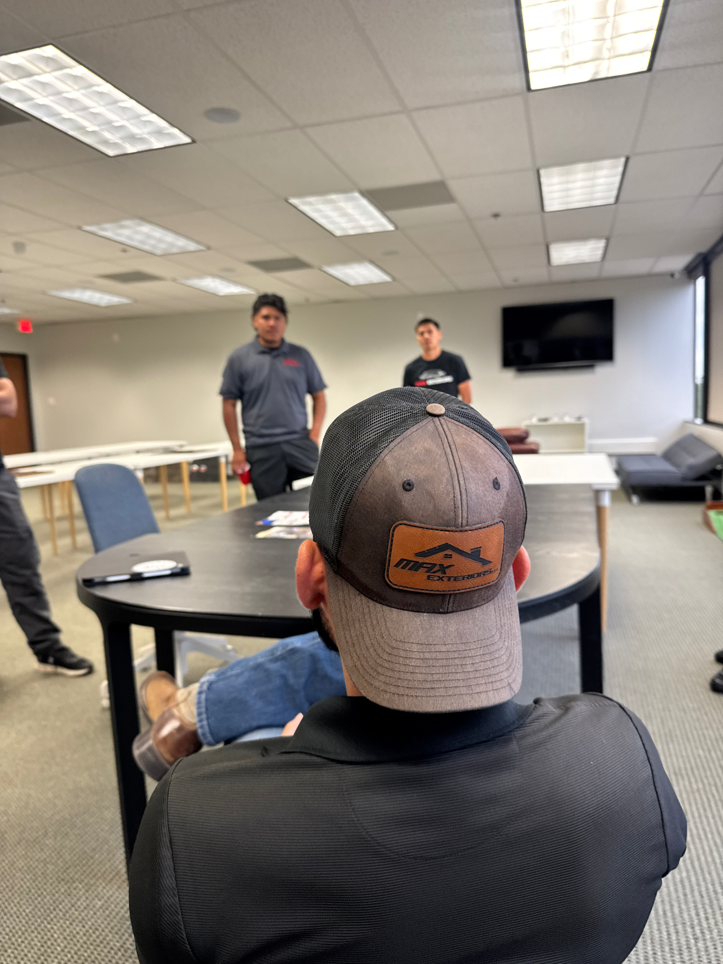 Max Exteriors training session with branded company hat in the foreground